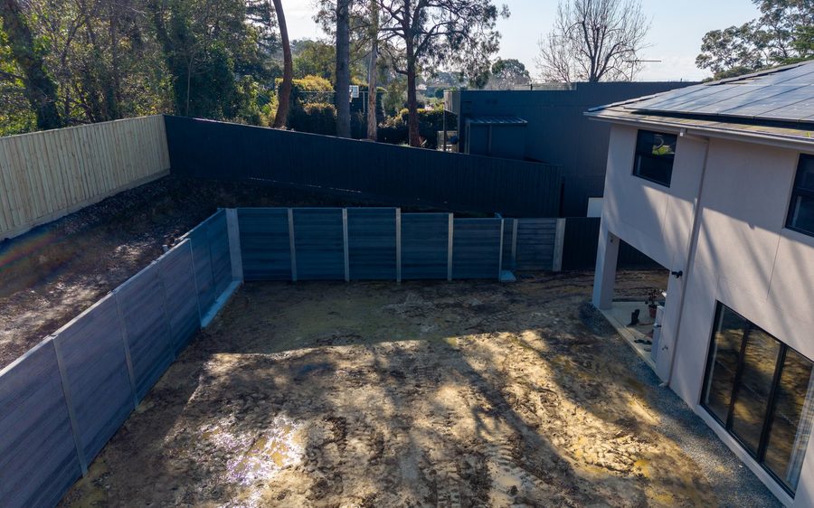 The finished walls read against the house they were built around