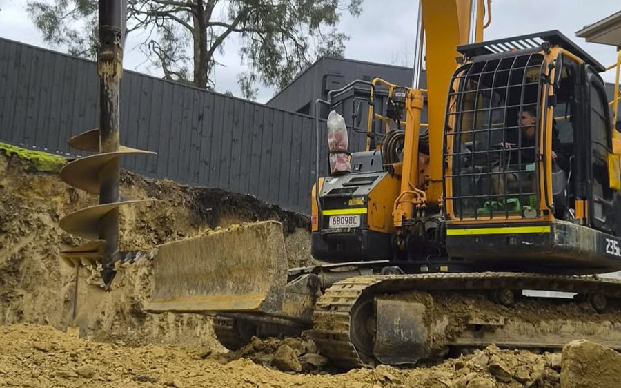 Auger drilling the footings for the structural steel posts